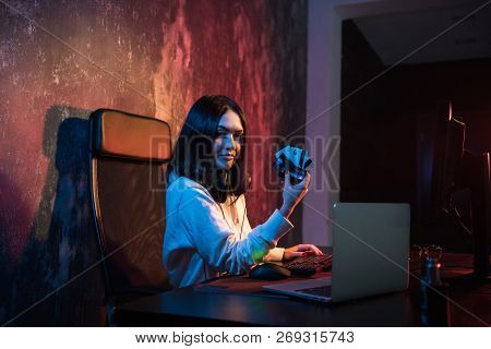 Closeup Of Young Female Theift In Sweatshirt With Hood Transfering Money From Bills Of Stolen Credin