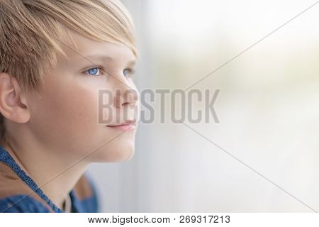 Sad Boy Looking Out Of Window. Portrait Of Depressed Blond Teen 12-14 Year Old