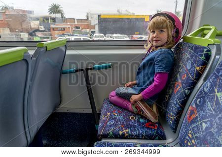 Young Girl In Pink Outfit And Pink Helmet Riding A Kick-scooter Across The Railway Line