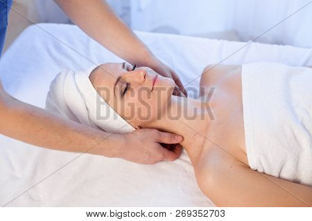 A Massage Therapist Makes A Woman Face And Neck Massage In The Spa