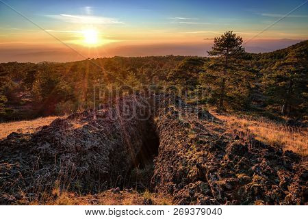 entrance of lava tube formed by volcanic activity in Etna Park at the sunset in Sicily