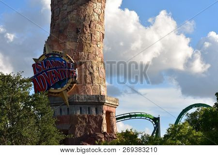 Orlando, Florida; July 27, 2018 Islands Of Adventure Sign And Roller Coaster At Universal Studios Ci