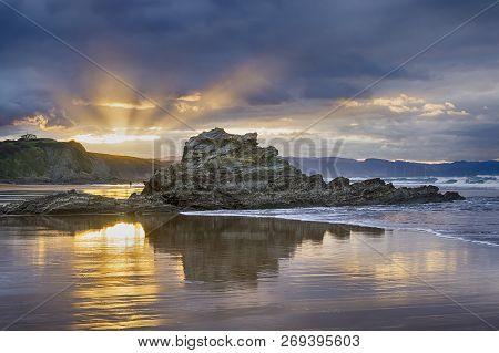 Dusk At The Arrietara Beach, In Sopela, Basque Country, Spain. With The Rock Peña Txuri Dominating T