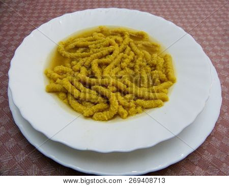 Passatelli In Brodo In A Plate On A Table