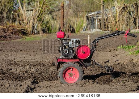 Gasoline Cultivator. Motoblock Plowing The Land With A Plow.