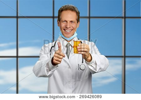 Happy Doctor With Pills On Sky Background. Joyful Caucasian Doctor Holding Mediction And Gesturing T