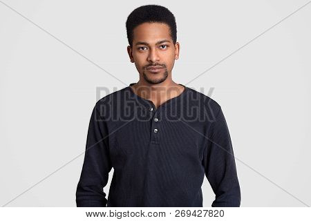 Serious Afro American Man Dressed In Casual Sweater, Has Self Confident Expression, Looks Directly A