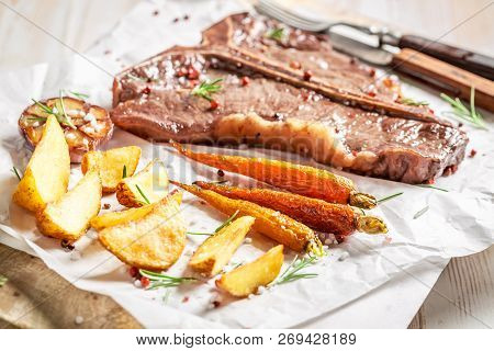 Tasty Tbone Steak Served With Water On White Table