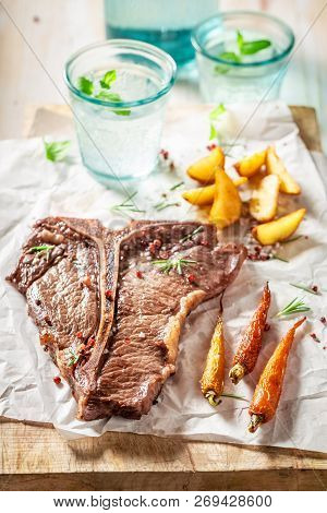 Yummy Tbone Steak Served With Water On White Table