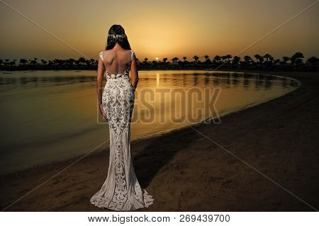 Woman In White Dress In Sunset Beach. Bride And Wedding Ceremony. Elegance And Fashion Model. Weddin