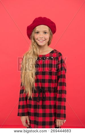 Kid Little Cute Girl With Long Hair Posing In Hat Red Background. Fashionable Beret Accessory For Fe