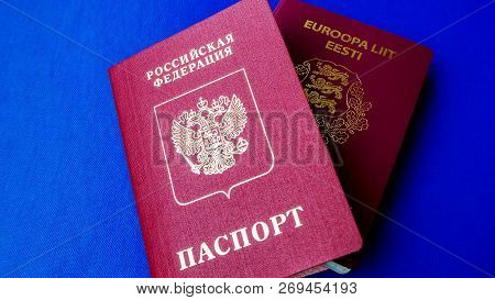 Passports On The Blue Background. Citizenship Of Estonia And Russia. Citizenship Of European Union (