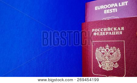 Passports On The Blue Background. Citizenship Of Estonia And Russia. Citizenship Of European Union (