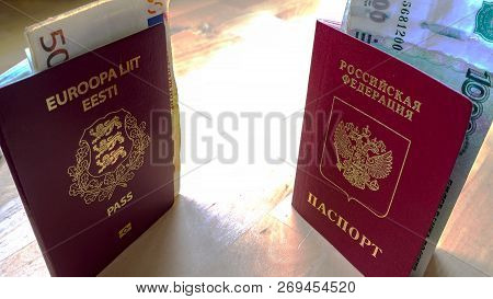 Passports On The Wooden Background. Citizenship Of Estonia And Russia. Citizenship Of European Union