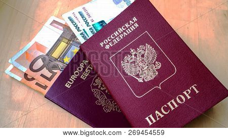 Passports On The Wooden Background. Citizenship Of Estonia And Russia. Citizenship Of European Union