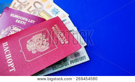 Passports On The Blue Background. Citizenship Of Estonia And Russia. Citizenship Of European Union (