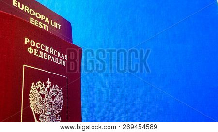 Two Passports On The Blue Textile Background. Dual Citizenship Of Estonia And Russia. Citizenship Of