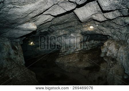 Beautiful Cave. View From Inside Dark Dungeon. Textured Walls Of Cave. Background Image Of Undergrou