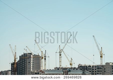 View Of Construction Of Close-up. Group Of Multifamily Building In Process Of Construction. Many Cra