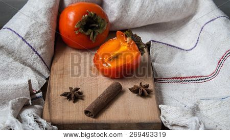 A Ripe Sliced Persimmon And Kitchen Towl