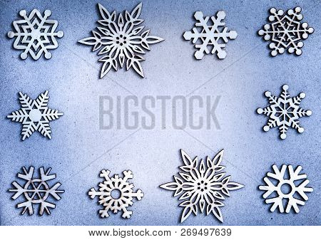 White Wooden Snowflakes Frame On Blue Craft Paper