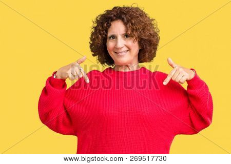Beautiful middle ager senior woman red winter sweater over isolated background looking confident with smile on face, pointing oneself with fingers proud and happy.