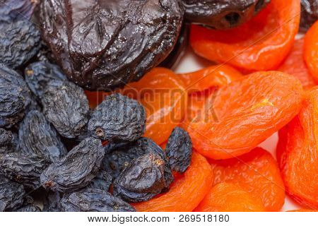 Dark-colored Raisins, Dried Plums And Dried Apricots Closeup At Selective Focus
