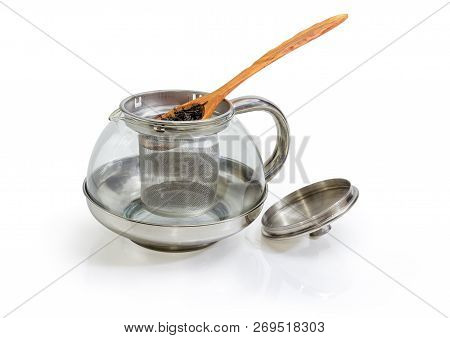Dried Large Leaves Of Black Tea In Wooden Spoon On Eempty Glass Teapot With Strainer And Open Lid On