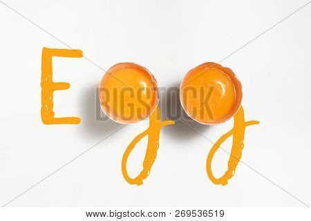 Word Egg Written With 2 Egg Yolks On White Table