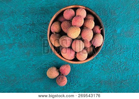 Lychee In A Wooden Bowl On A Blue Cement Background. Lychee On The Background Of Blue Cement. Turquo