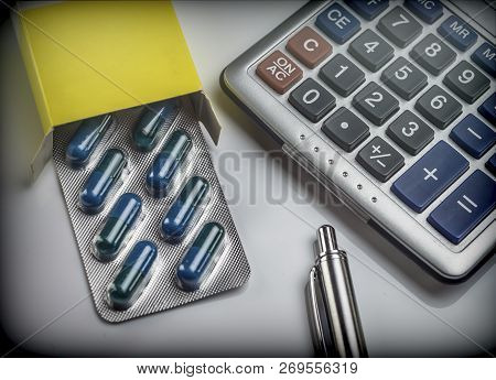 Blister Pack Of Pills Next To A Calculator, Concept Of Copayment Health
