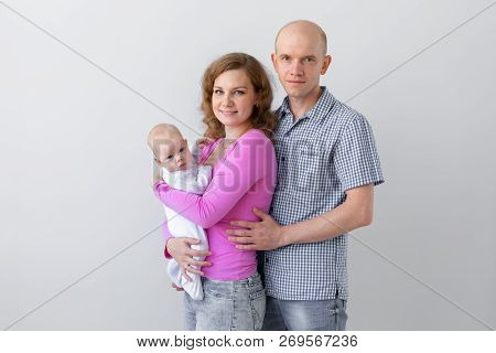 Family, Childhood And Parenthood Concept - Father, Mother Holding Cute Baby Over White Background Wi
