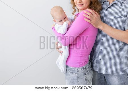 Family, Childhood And Parenthood Concept - Close Up Of Father, Mother Holding Cute Baby Over White B