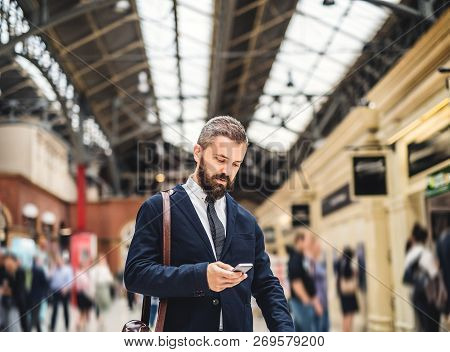 Businessman With Smartphone On The Trian Station In London, Texting.