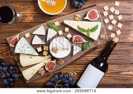 Cheeseboard With Cheese Brie , Parmesan , Camembert And Dorblu . Food On Wooden Board