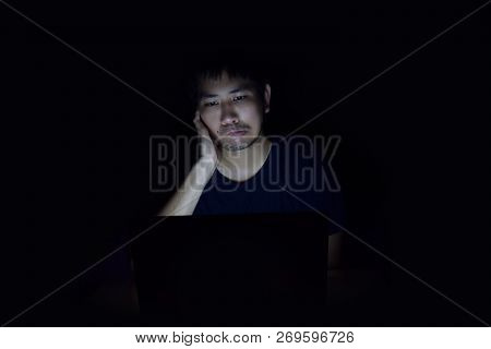 Asian Man Using Laptop In The Black Dark Room And Show Annoy Something On His Face