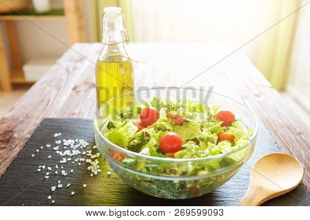 Salad With Tomatoes In Glassy Bowl On Wooden Table