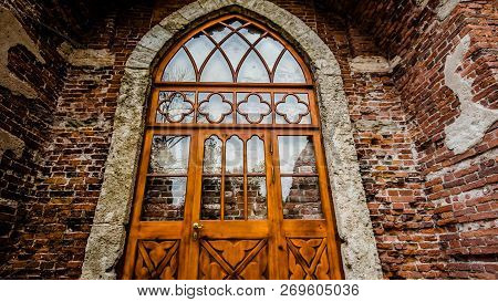Brown And Red Brick Wall Textured Background And Wooden Door And Arch