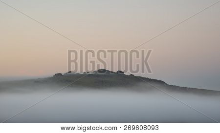 Stunning Foggy Sunrise Landscape Over The Tors In Dartmoor Revealing Peaks Through The Mist