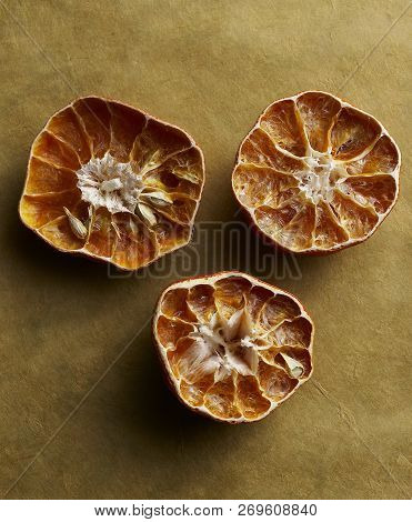 Dried Up Tangerines Intact On Gold Paper Background