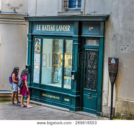 Paris, France - July 07, 2018: Two Girls Watching Historic Le Bateau Lavoir Store Window