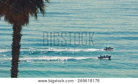 Two Small Motor Boats Sailing In The Atlantic Ocean. Just Water And Two Boats. Blue Waves, No Sky. A