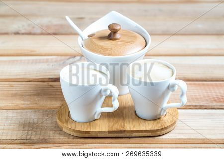 Coffee Creamers. Two Cups Of Coffee On A Wooden Table.