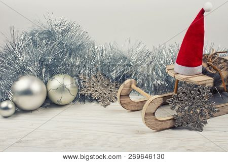 Christmas Or New Year Decorations (wooden Toy Christmas Sleigh With A Santa Hat, Silver Tinsel, Snow