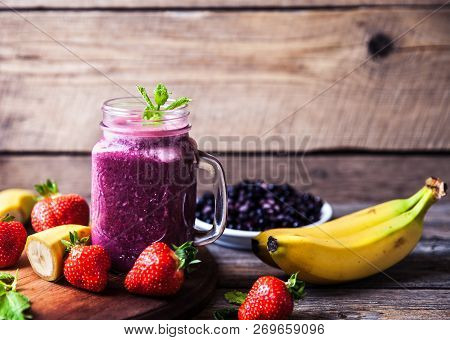 Blueberry Smoothies On A Wooden Background With Fruits. Vitamins A