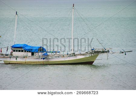 Traditional Outrigger Boat Anchored At Labuan Bajo Town On Flores Island, Nusa Tenggara, Indonesia. 