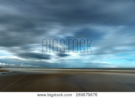 Dramatic Stormy Clouds Over Beach With Coastal Buildings And Sea