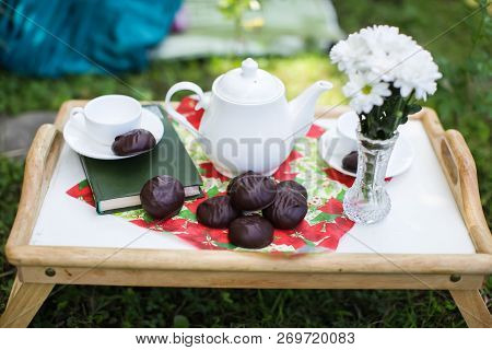 The Table Set For Afternoon Tea In A Summer Garden - White Tea-things, Book, Marshmallows, Flowers I
