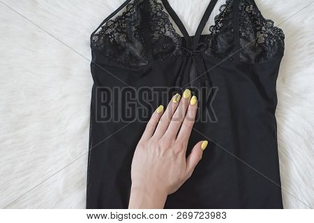 Fashionable Concept. Black Lace Pyjama Vest And Femalehand On White Fur.