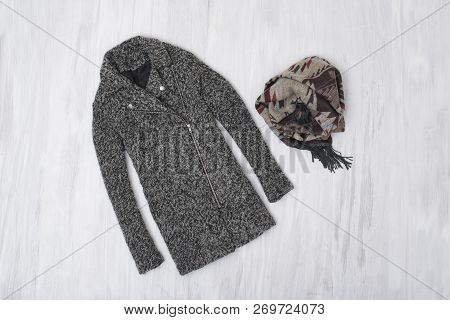 Gray Woolen Coat And Skarf On Wooden Background. Fashionable Concept